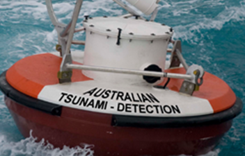 Australian Tsunami Detection buoy floating at sea, with a red circular base and white instrument housing designed to monitor ocean conditions and support tsunami warning systems.