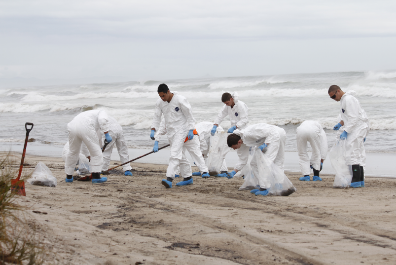 Volunteers help clean-up Papamoa Beach in the Bay of Plenty after an oil spill from MV Rena in 2011. Image: Reproduced with permission by Sunlive, New Zealand