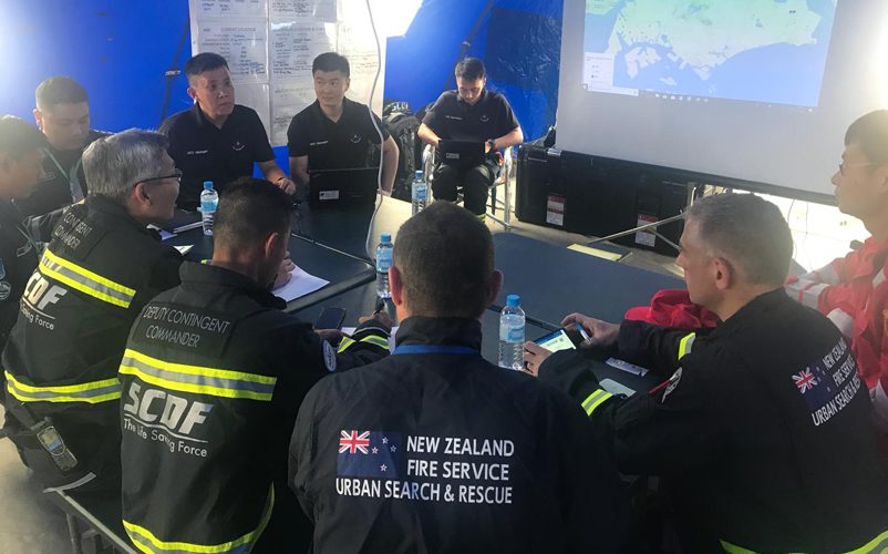 USAR teams conduct a coordination meeting at an On-Site Operations Coordination Centre during the IER for the Singapore Civil Defence Force in 2018. Image: Yosuke Okita